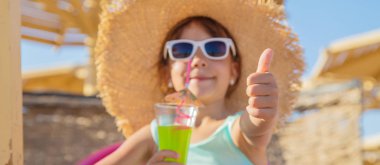 Denizde bir çocuk kokteyl içer. Seçici odak.