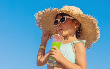 Denizde bir çocuk kokteyl içer. Seçici odak.