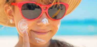 Bir çocuğun teninde güneş kremi. Seçici odak.