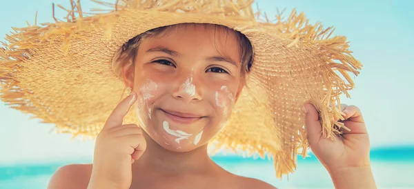 Bir çocuğun teninde güneş kremi. Seçici odak.