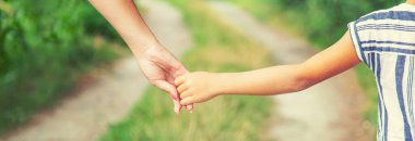 çocuk annesiyle el ele gider. Seçici odak. Doğa.