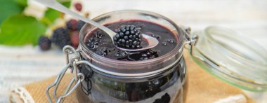 Kavanozda böğürtlen reçeli. Seçici odak. Doğa