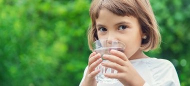 çocuk bir bardaktan su içer. Seçici odaklama.