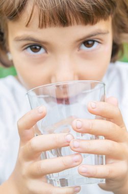 çocuk bir bardaktan su içer. Seçici odaklama.