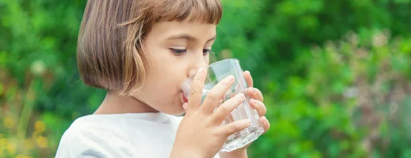 孩子从玻璃杯里喝水 选择性聚焦 — 图库照片