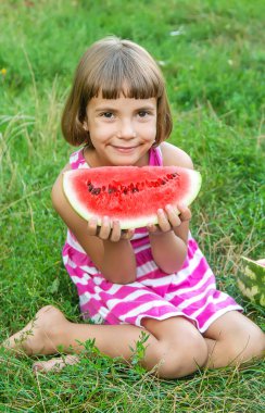 çocuk bahçede karpuz yer. Seçici odaklama.