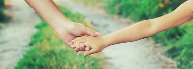 Anne ve çocuk el ele gider. Seçici odaklanma. Doğa.