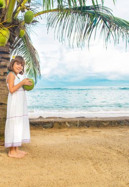 Sahilde hindistan cevizi içen bir çocuk. Seçici odak.
