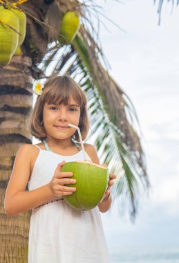 Sahilde hindistan cevizi içen bir çocuk. Seçici odak.