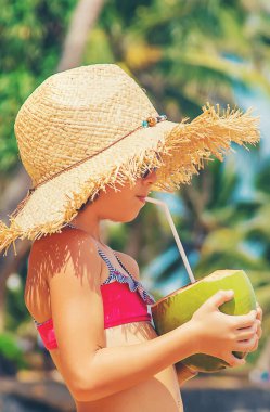 Sahilde hindistan cevizi içen bir çocuk. Seçici odak.