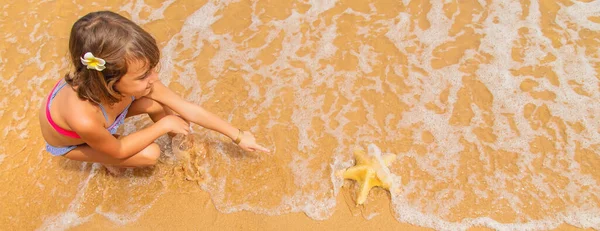 Ребенок Морской Звездой Ракушками Руках Пляже Селективный Фокус — стоковое фото