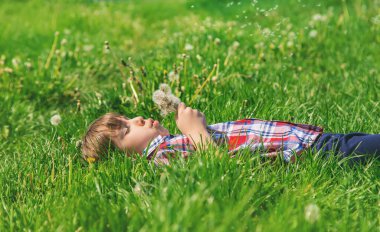 Parkta karahindiba taşıyan kız çocuğu. Seçici odak.