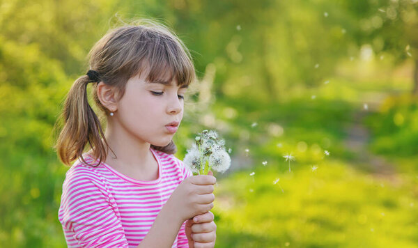 Child girl with dandelions in the park. Selective focus.