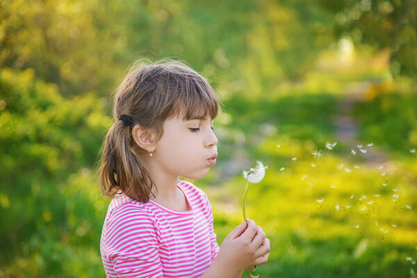 Child girl with dandelions in the park. Selective focus.