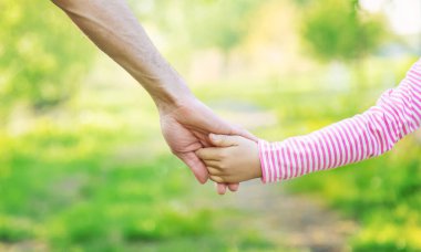 Babasıyla birlikte bir çocuk elden gider. Seçici odaklanma. Doğa.