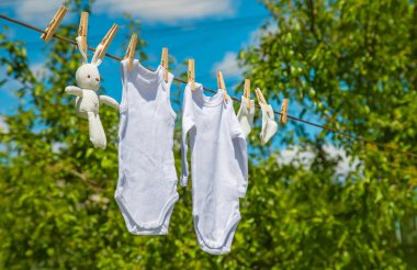 Beyaz bebek kıyafetleri iple kurumuş. Seçici odaklanma. Doğa.