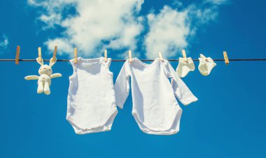 Beyaz bebek kıyafetleri iple kurumuş. Seçici odaklanma. Doğa.