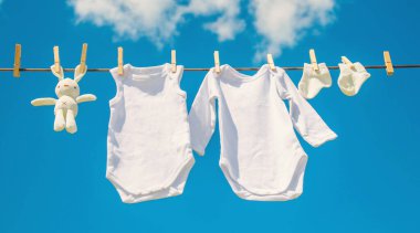 Beyaz bebek kıyafetleri iple kurumuş. Seçici odaklanma. Doğa.