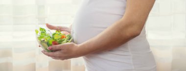 Hamile bir kadın sebzeli salata yer. Seçici odaklanma. Yiyecek..