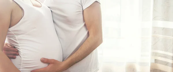 一个孕妇和一个孩子的父亲抱着一个肚子 有选择的重点 — 图库照片