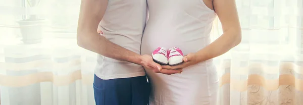 Pregnant Woman Man Hug Belly Hold Baby Shoes Selective Focus — Stock Photo, Image