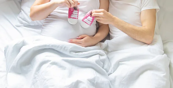 Pregnant Woman Man Hug Belly Hold Baby Shoes Selective Focus — Stock Photo, Image