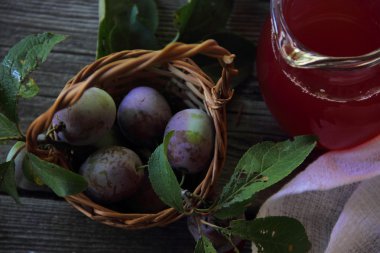 taze erik bir hasır sepet ve komposto bir kavanoz içinde
