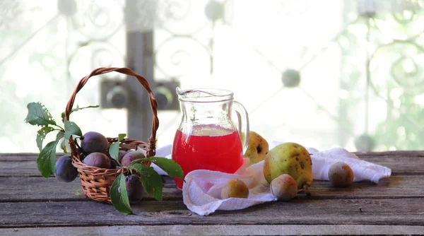 Komposit pir dan plum dalam kendi transparan — Stok Foto