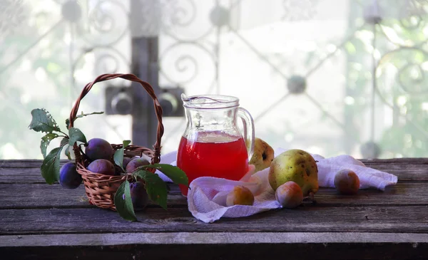 Komposit pir dan plum dalam kendi transparan — Stok Foto