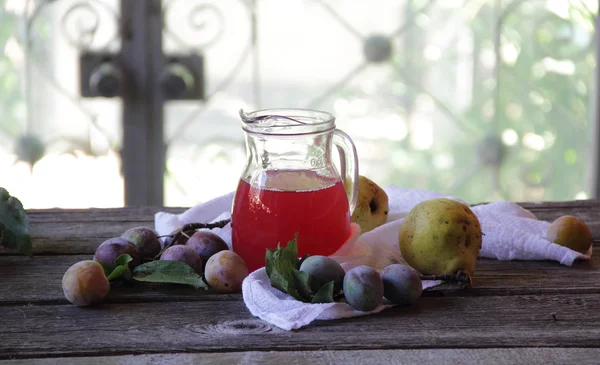 Komposit dari plum dan pir dalam kendi transparan — Stok Foto