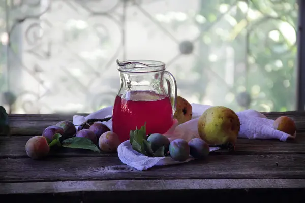 Komposit dari plum dan pir dalam kendi transparan — Stok Foto