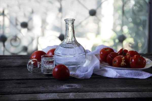 Горілка у графин і фаршировані помідори маринованих — стокове фото