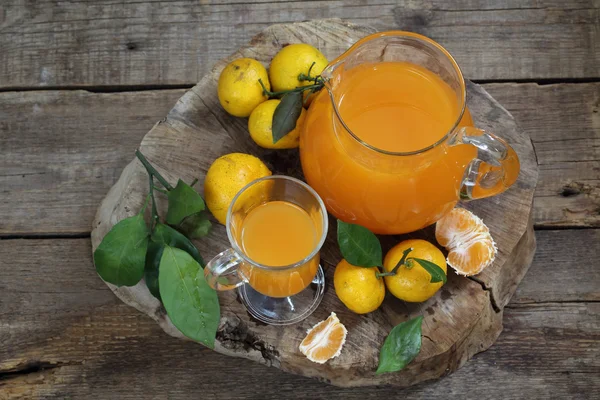 Martwa natura z mandarynki sok w dzban i świeże mandarynki — Zdjęcie stockowe
