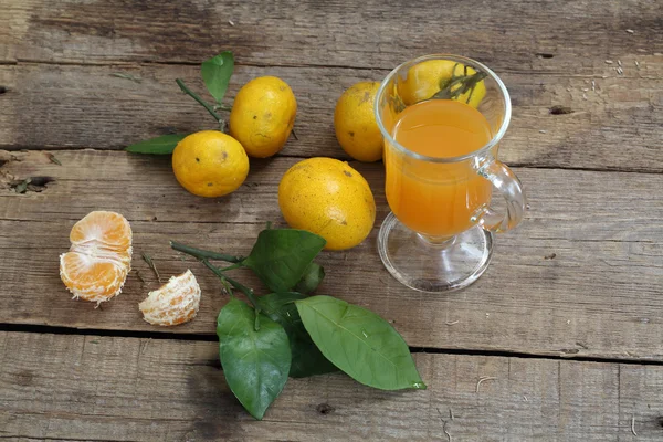 Мандариновий сік у склянці та свіжі мандарини — стокове фото