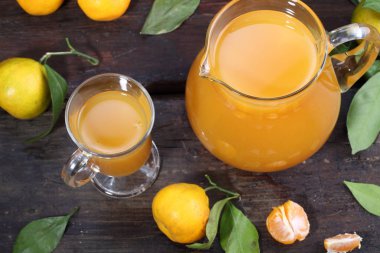 ahşap bir masa üzerinde açık sürahi mandalina suyu