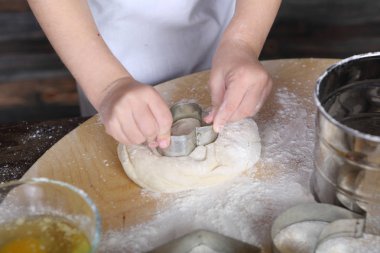 küçük bir kız kurabiye hamuru bir şekil keser