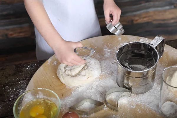 A little girl cuts out a shape of cookie tough — стоковое фото