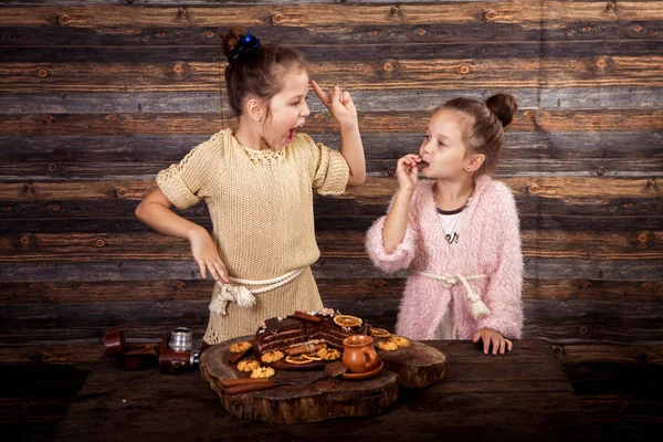 Die Mädchen essen Schokoladenkuchen und Kekse — Stockfoto
