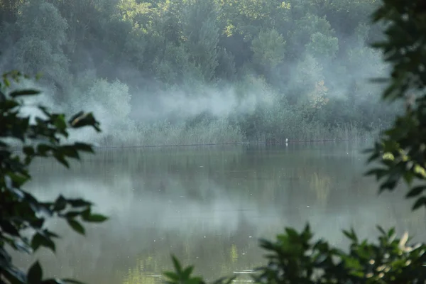 A fumaça do fogo que se espalha sobre o rio — Fotografia de Stock