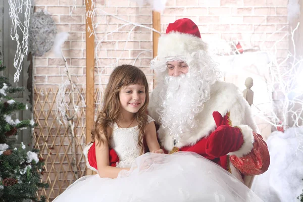 Noel Baba'nın kucağına oturan güzel elbiseli kız — Stok fotoğraf