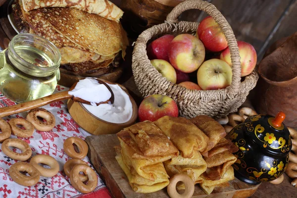 Nature morte avec crêpes, crème sure et pommes sur une table en bois — Photo