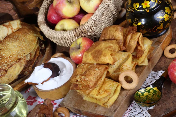 Pfannkuchen mit saurer Sahne und Äpfeln auf einem Holztisch. Karneval — Stockfoto