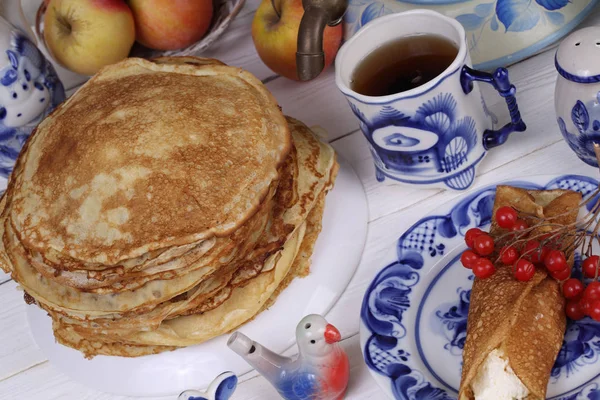 Pancake ditumpuk di piring dan teh di cangkir yang indah — Stok Foto