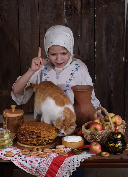 Dívka u stolu dovolená s kočkou. Karneval — Stock fotografie