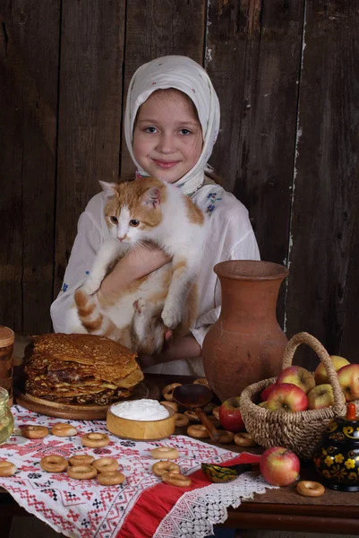 A lány a macska az ünnepi asztalra. Karnevál — Stock Fotó