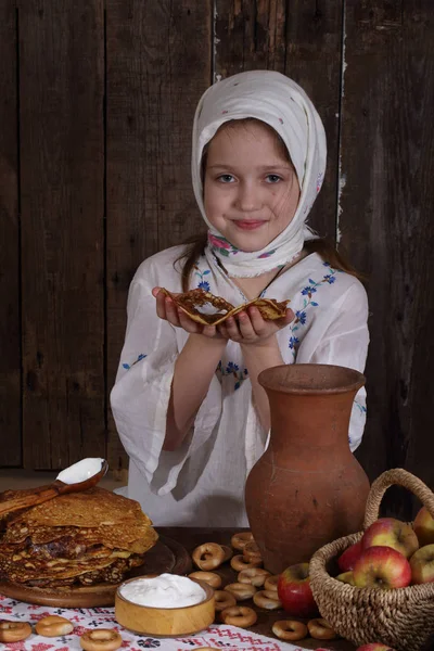 Menina comendo panquecas durante Maslenitsa — Fotografia de Stock