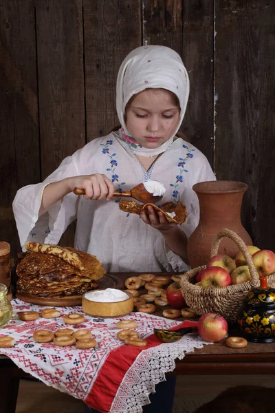 Girl eating pancakes during Maslenitsa — Stock Photo, Image