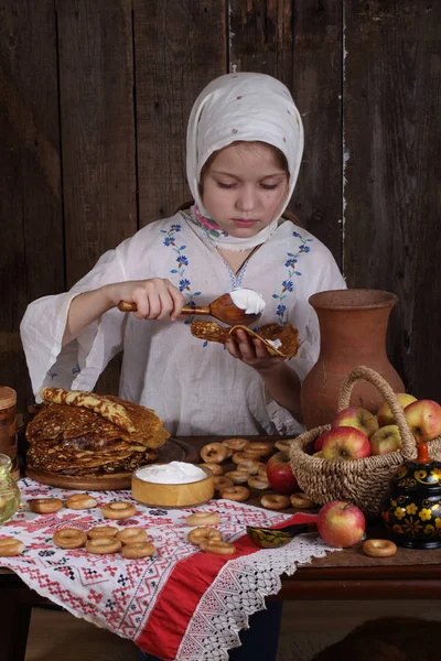 Menina comendo panquecas durante Maslenitsa — Fotografia de Stock