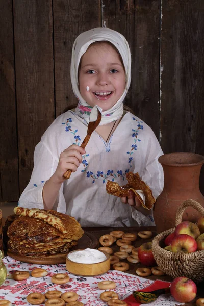 Menina comendo panquecas durante Maslenitsa — Fotografia de Stock