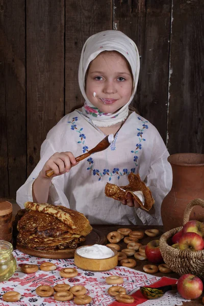 Menina comendo panquecas durante Maslenitsa — Fotografia de Stock